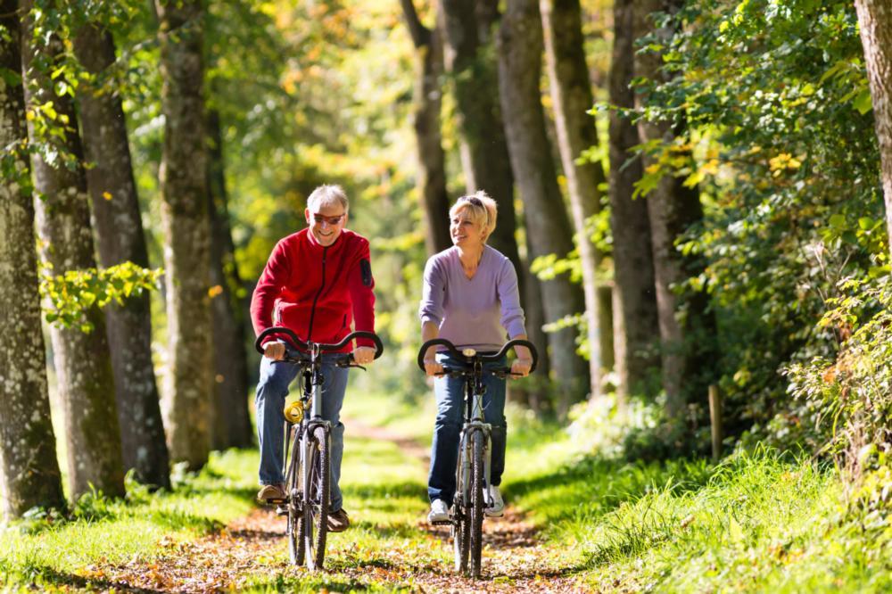 Image of couple riding their bikes in the forest | Bethlehem Town Family Dental | Glenmont, NY