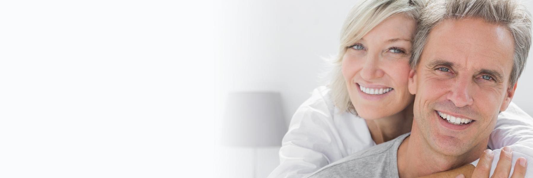 Patients smiling with their new complete dentures