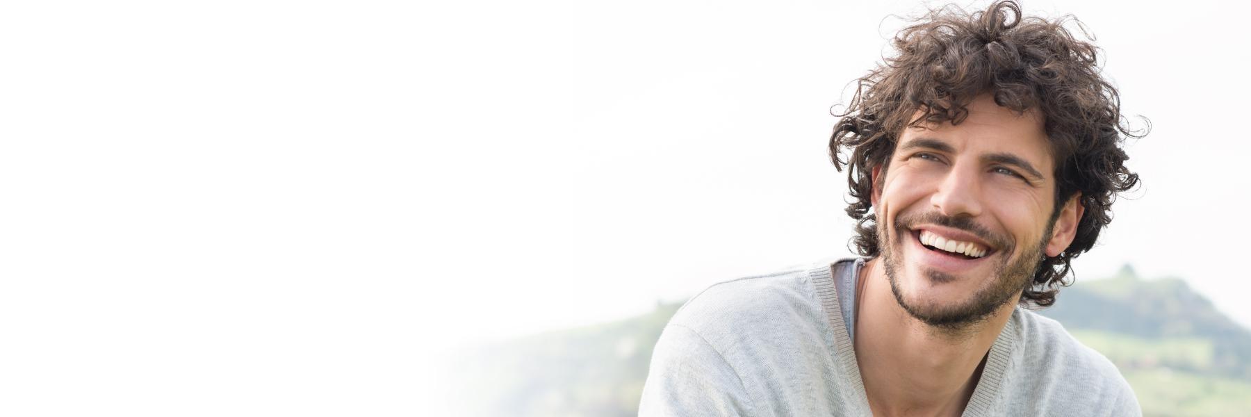 Curly Haired Invisalign patient smiling in Glenmont, NY